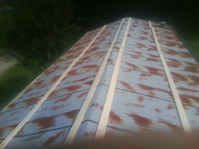 Rusted metal roof panels with new wood purlins before replacement — Storm Damage Roof Repair in Coin by Roofing Brothers